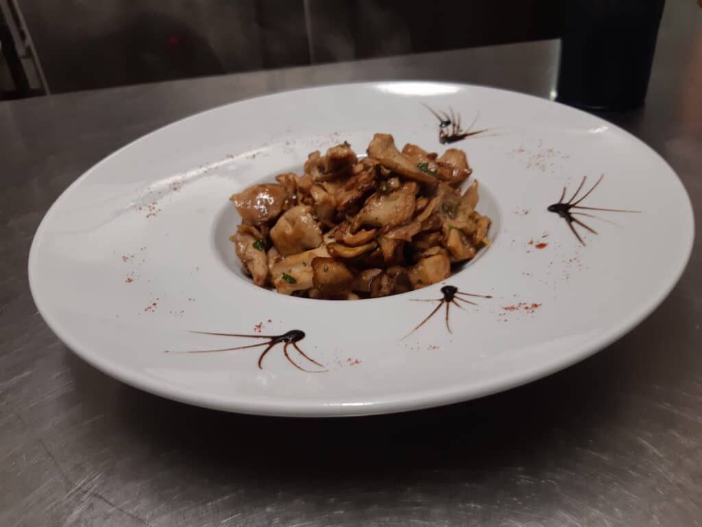 Poêlée de champignons gourmande, décorations de balsamique et épices sur une assiette blanche élégante.